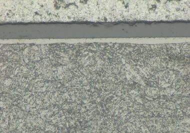 Lichtmikroskopischer Querschliff: dunkle DLC-Schicht auf nitrierter Randzone