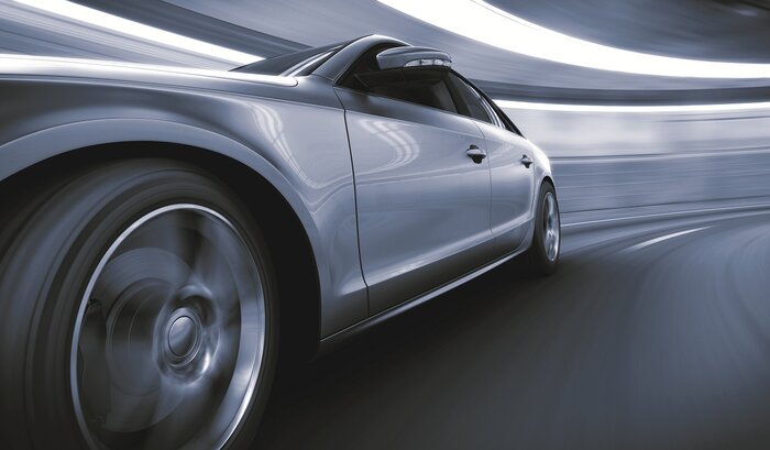 futuristisches Auto in silber im Vordergrund zu sehen ein Reifen