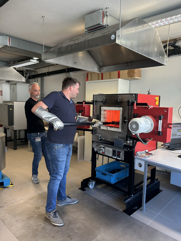 Teilnehmer der RÜBIG Seminare: Werkstofftechnik und Wärmebehandlung führen im Rahmen eines RÜBIG Seminars eine praktische Wärmebehandlung an einem Werkstück in einem Industrieofen durch.